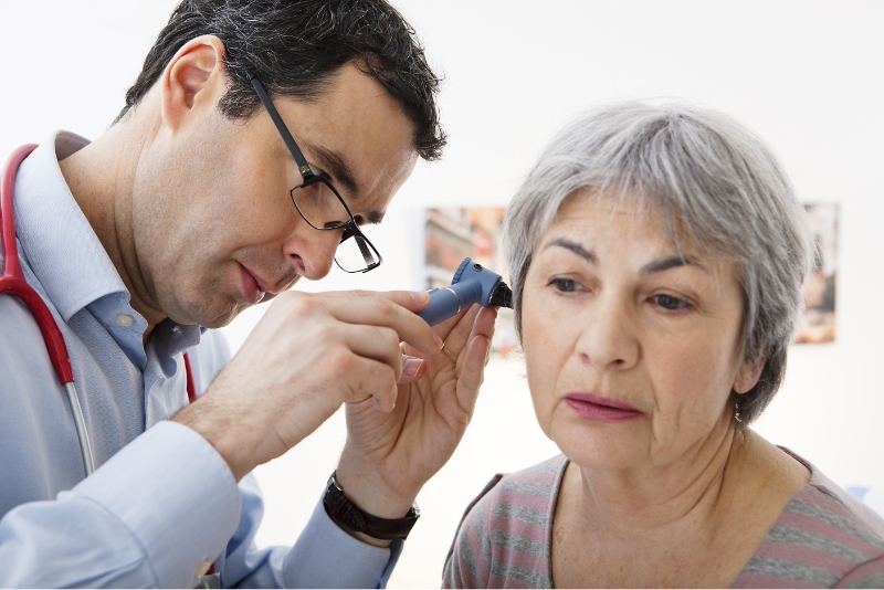 An audiologist examining a patient's ear